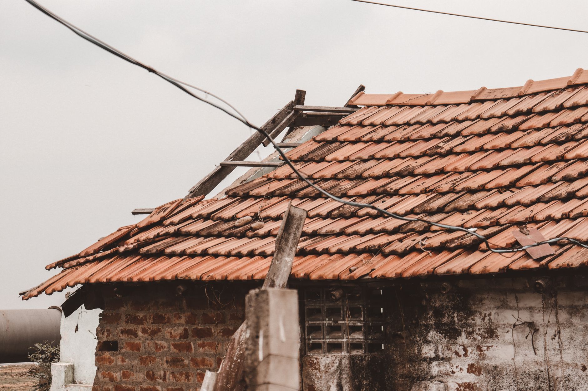 Damaged clay tile roof with displaced and broken tiles